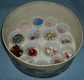 On the bottom layer of the box, I set little condiment cups to hold items used only occasionally--my Christmas pins, for instance. The 3 shelves will stack on top of this layer.