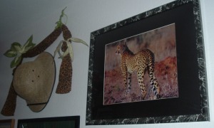 The cheetah puzzle hangs on the study wall next to a safari hat and leopard-print scarf.