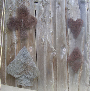 A wire spade, club, heart, and diamond greet everyone who passes by the fence.