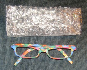 The reading glasses were fifty cents, and the bubble-wrap case was free. Both work great when I pack light for writing sessions.